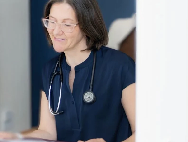 Dr. Brenda Walkey smiling and reviewing health records