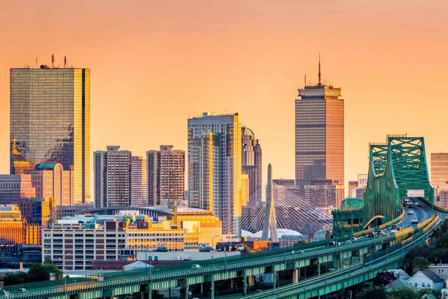 Boston skyline at sunset with the Zakim Bridge and city skyscrapers.