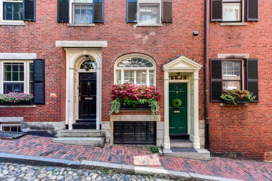 Historic brick townhouses with flower boxes on a Beacon Hill street.